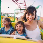 Little son and daughter with mother on roller coaster ride