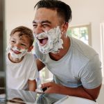 Happy father and son having fun while shaving